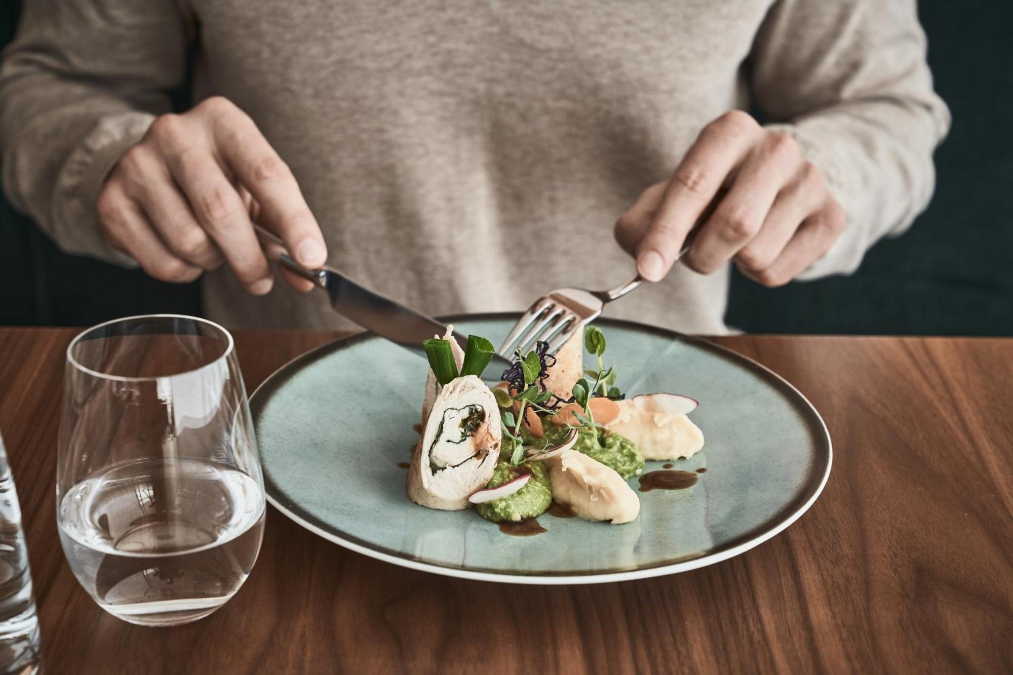 Falkensteiner Balance Resort Stegersbach - Adults Only Eksteriør billede A person using a knife and fork to cut into a meal